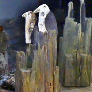 Zwei handgefertigte Keramik-Pinguine auf verwittertem Altholz, ideal für die Dekoration von Haus und Garten.
