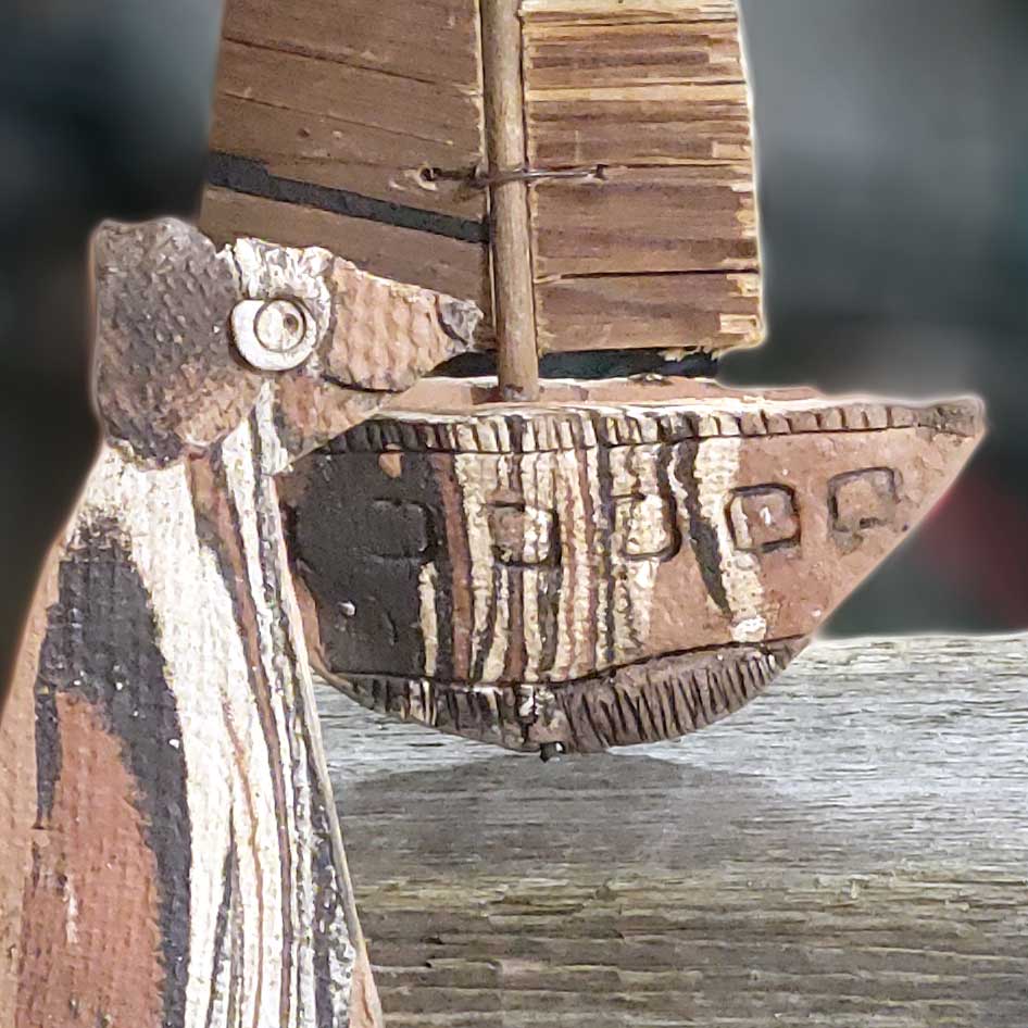 Maritime Deko aus Altholz und Keramik: Ein handgefertigtes Segelboot mit Hundefigur im Coastal-Look als stilvolle Dekoration für Haus und Garten.