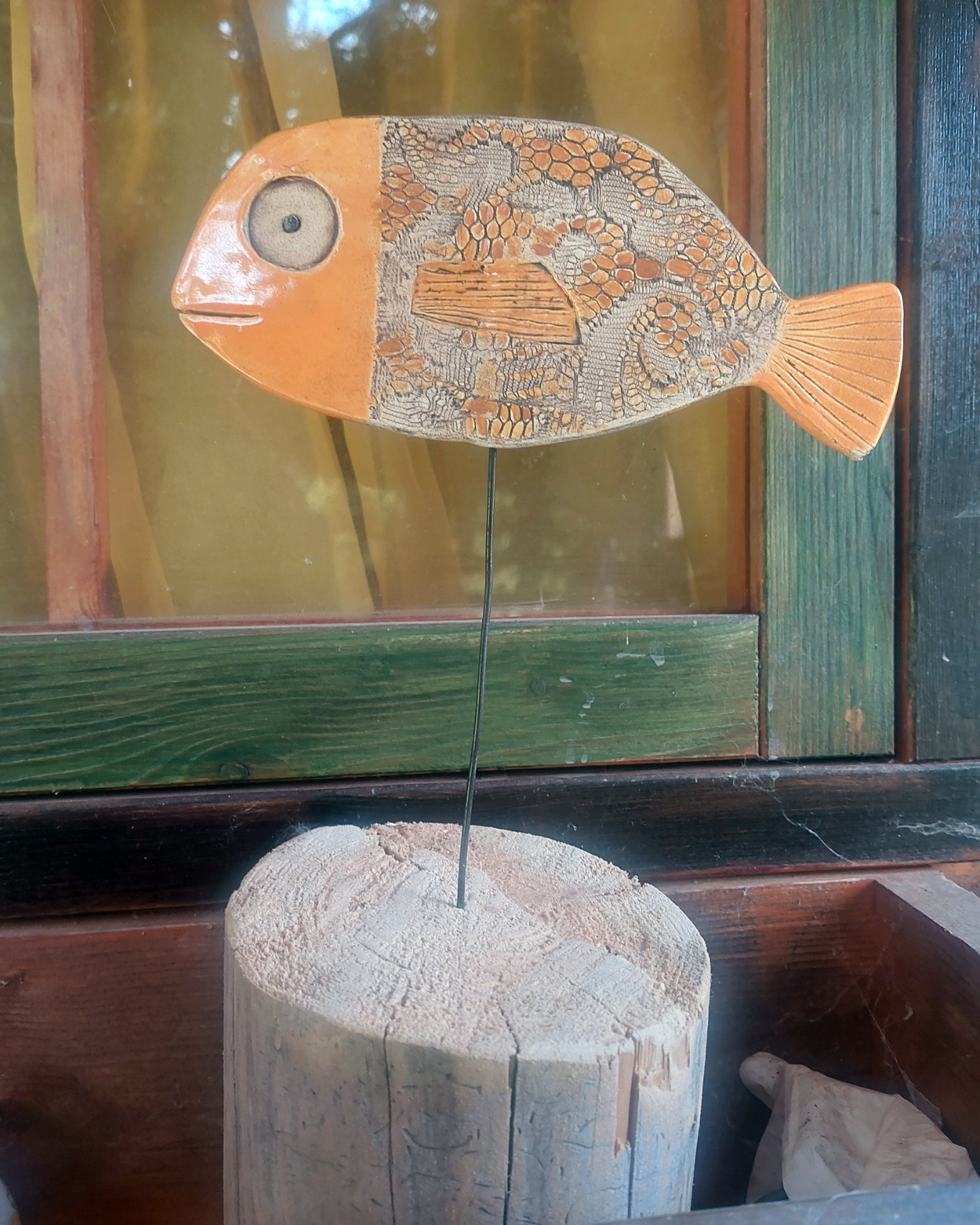 Handgearbeiteter Keramikfisch in Orange mit strukturiertem Muster, ideal für die Dekoration im Innen- oder Außenbereich.