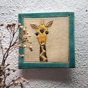 Quadratische Keramikfliese mit handgezeichnetem Giraffenmotiv in Gelb und Blau, ideal als dekoratives Wandbild für ein liebevolles Zuhause.