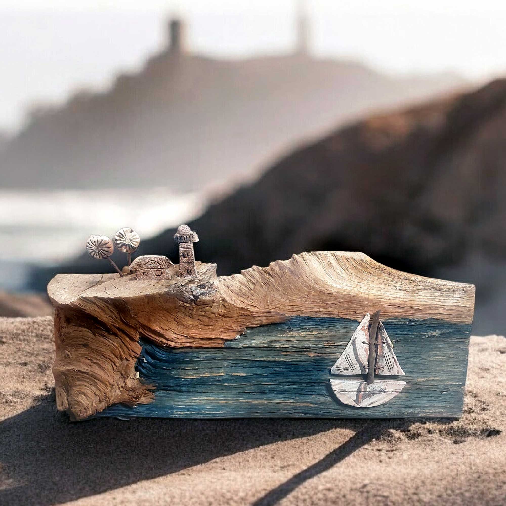 Handgefertigte Keramik Deko auf Treibholz mit Leuchtturm und Segelboot, ideal als maritime Tischdekoration für ein maritimes Wohnambiente.